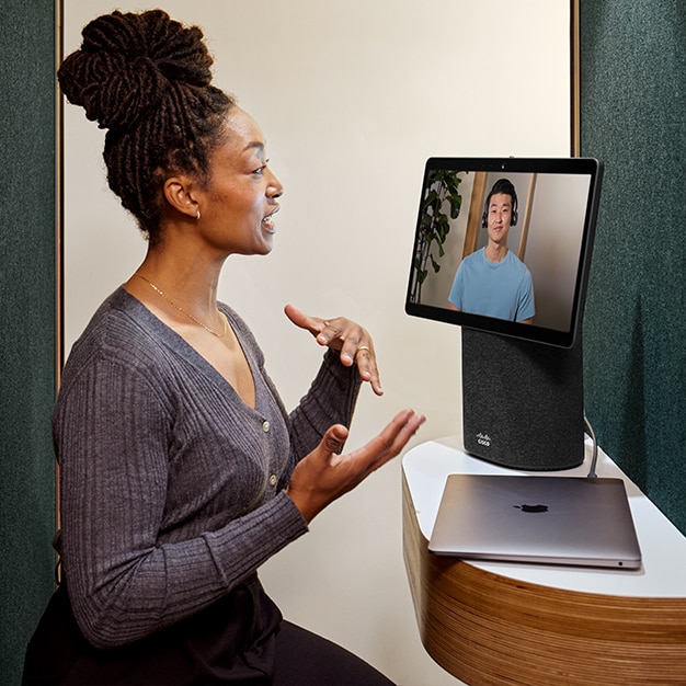 Person collaborates with a colleague on a virtual meeting, using a Create an instant workspace with the portable video conferencing device designed for taking meetings with you to any room..